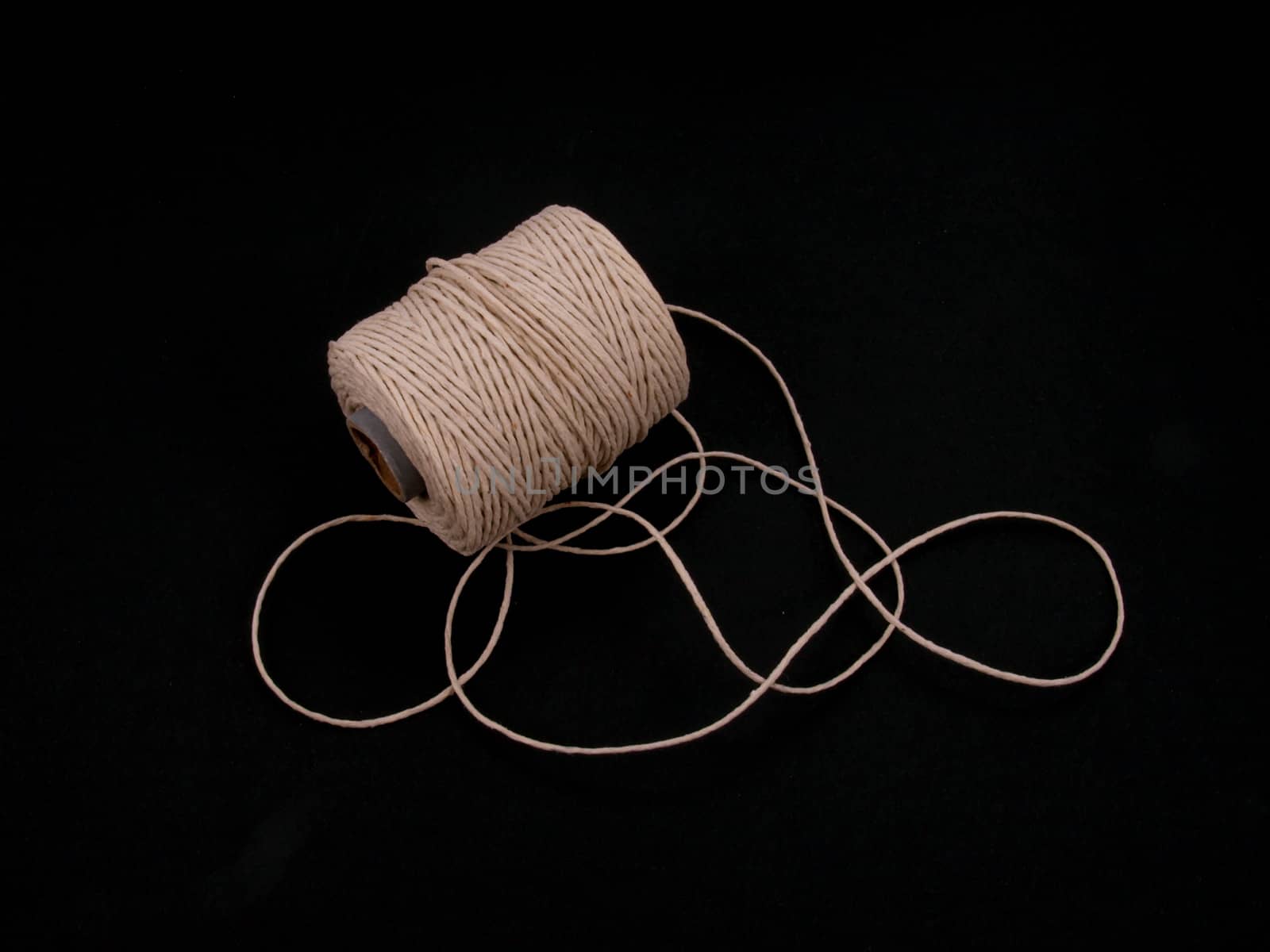 Ball of string or twine on a plain black background.