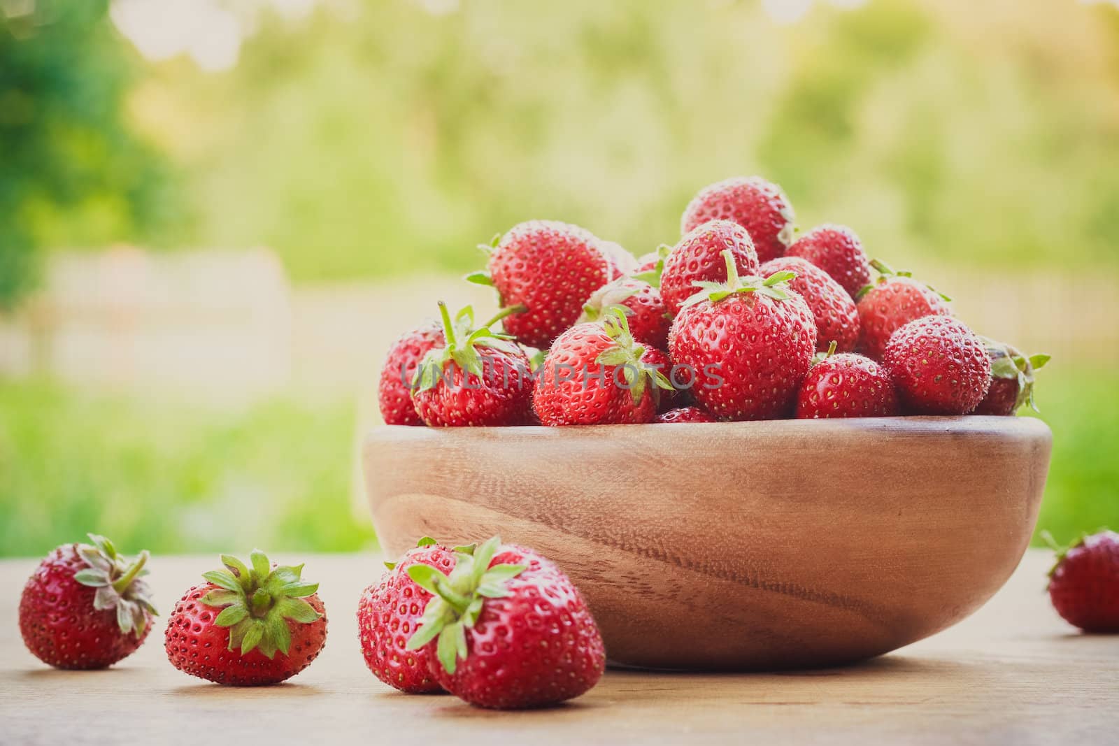 Close-Up Of Strawberries In Vintage Wooden Bowl On Table by ryhor