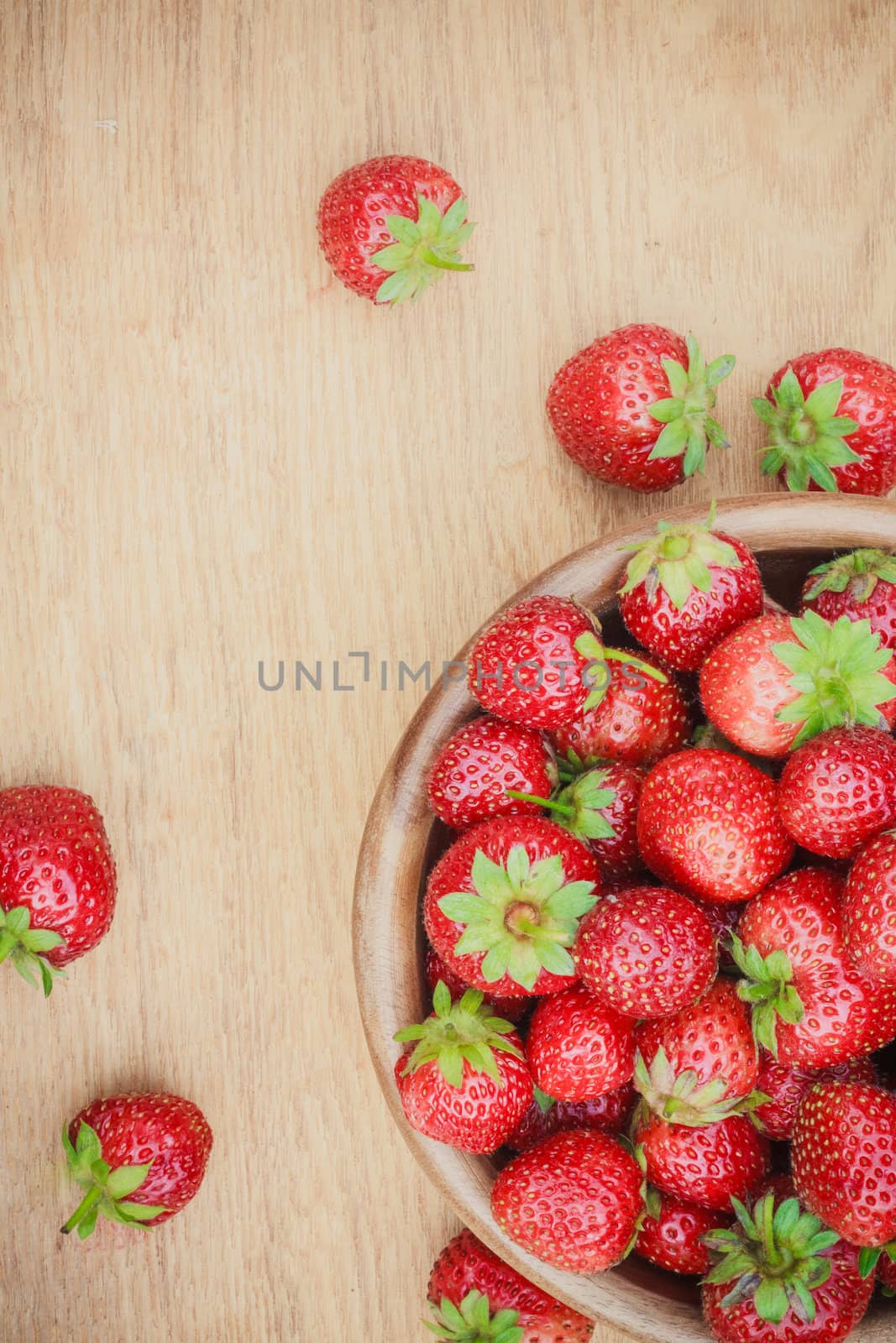 Old Wooden Bowl Filled With Succulent Juicy Fresh Ripe Red Strawberries On An Old Table top