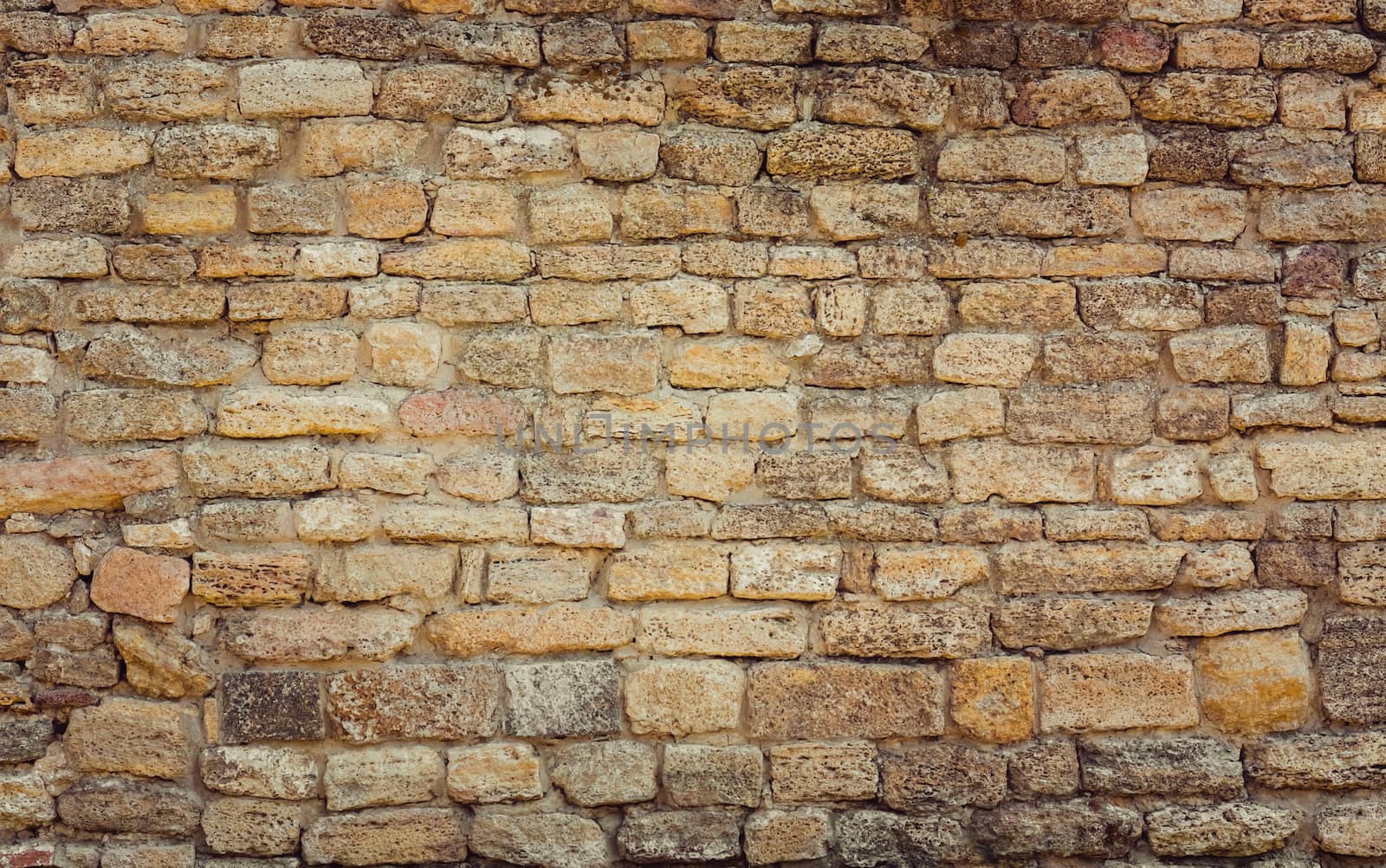 Old wall made of the Jerusalem stone. Wall constructed of stone bricks.