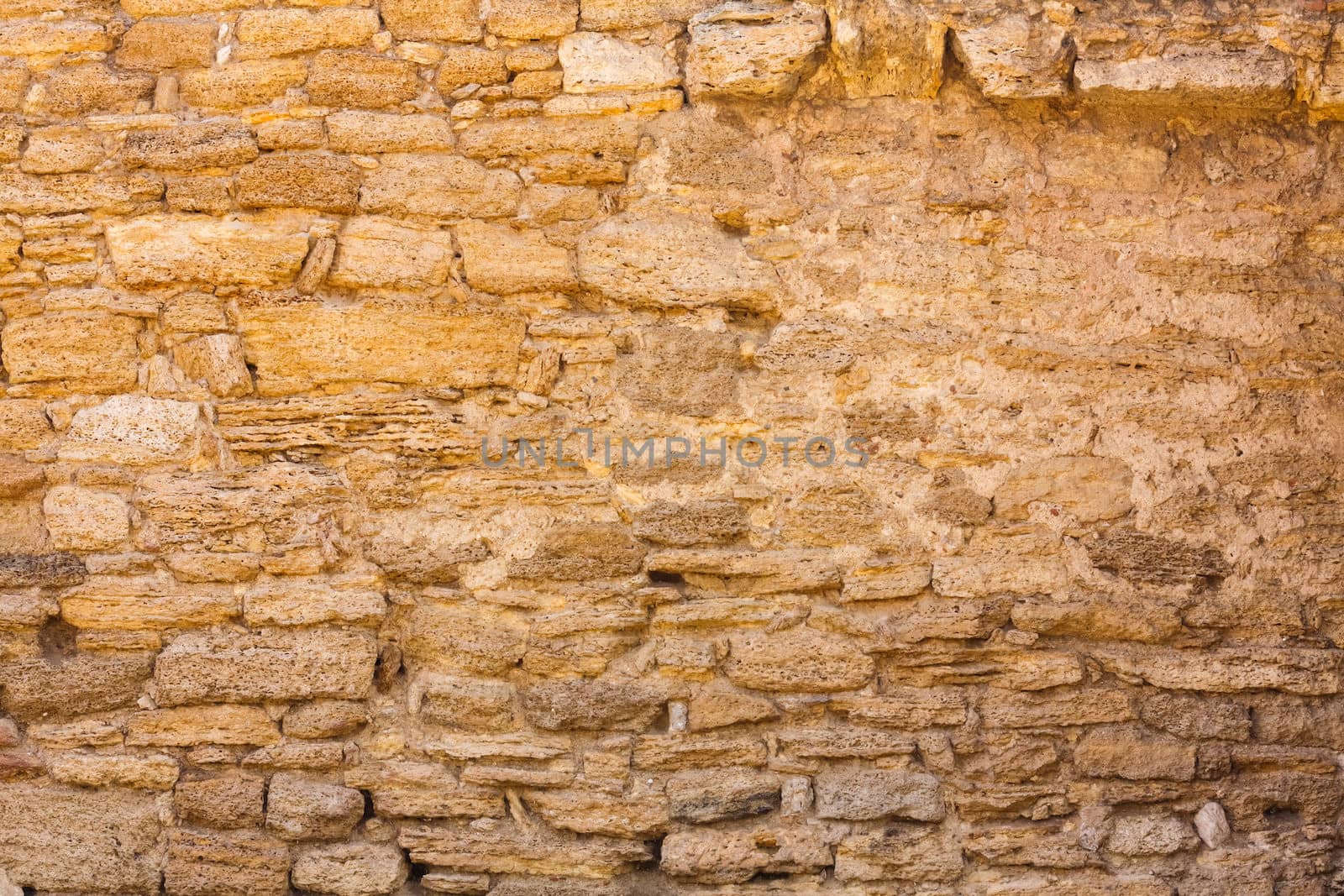 Old wall made of the Jerusalem stone. Wall constructed of stone bricks.