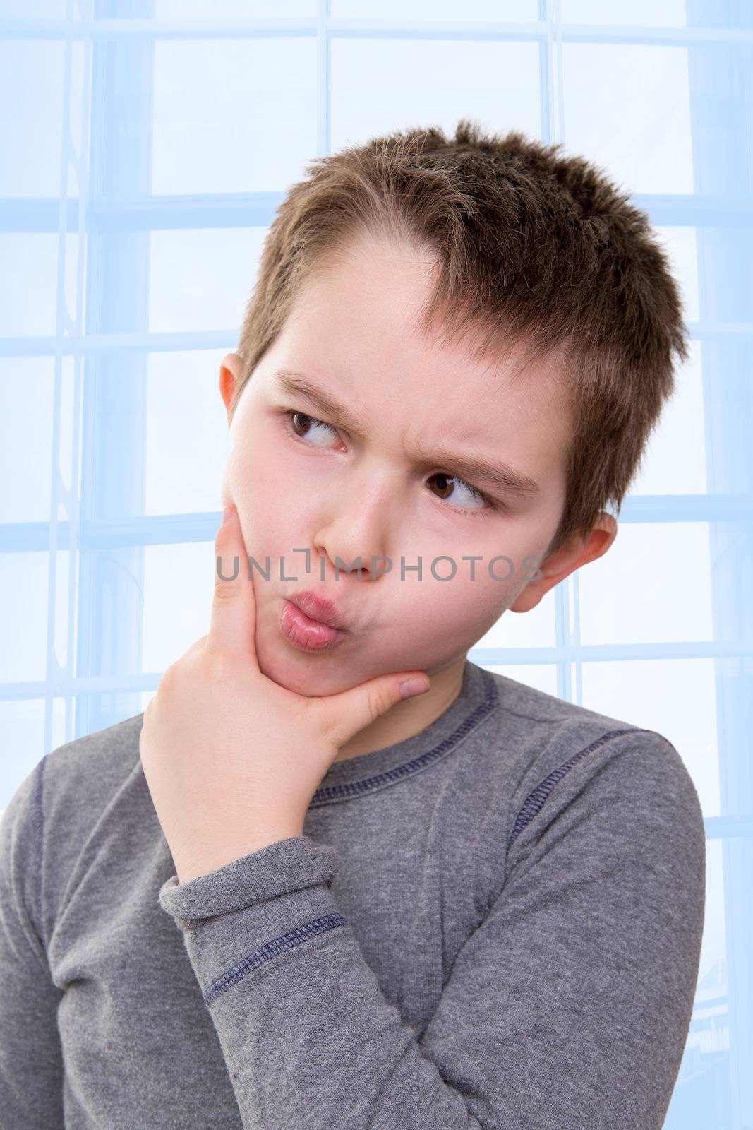 Kid looking away very doubtfully or there might be a math problem he thinks about