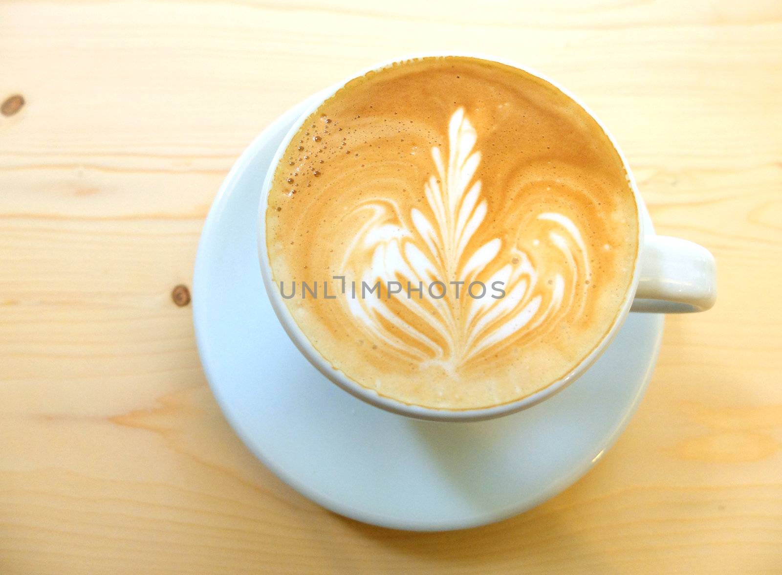 Latte art coffee on wooden table