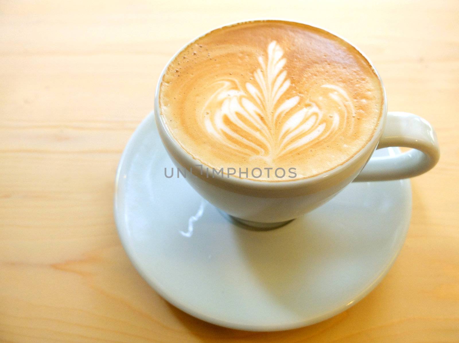 Latte art coffee on wooden table