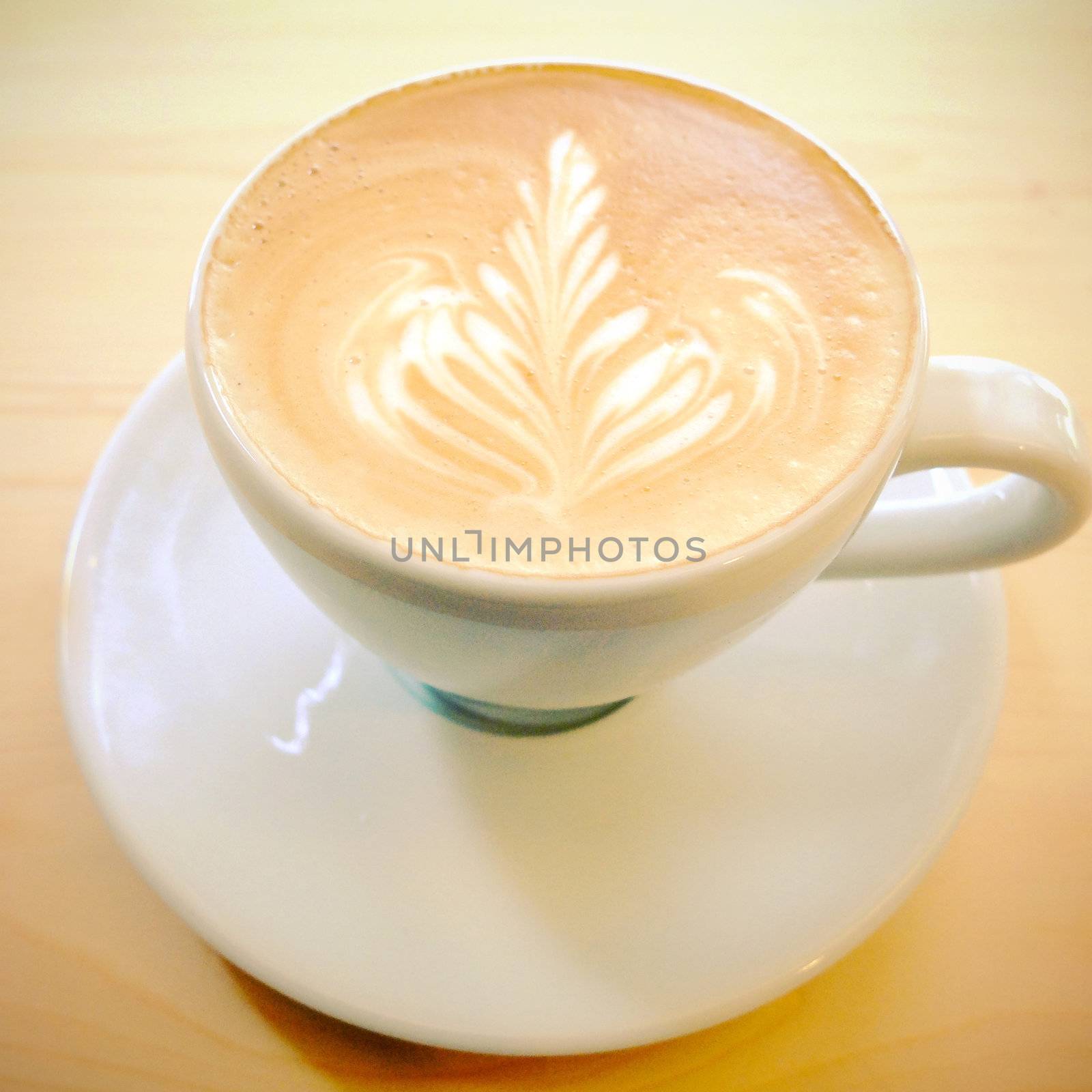 Latte art coffee on wooden table with retro filter effect