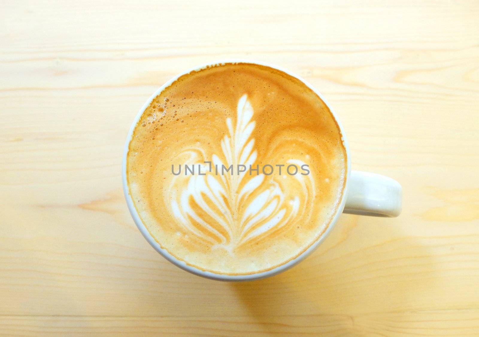 Latte art coffee on wooden table