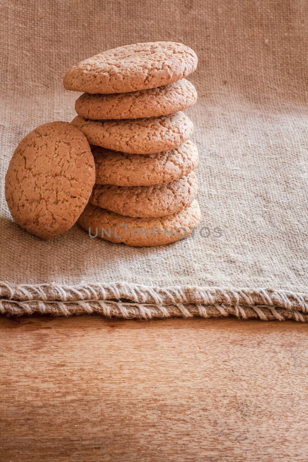 Stacked Brown Cookies On Rustic Background by ryhor