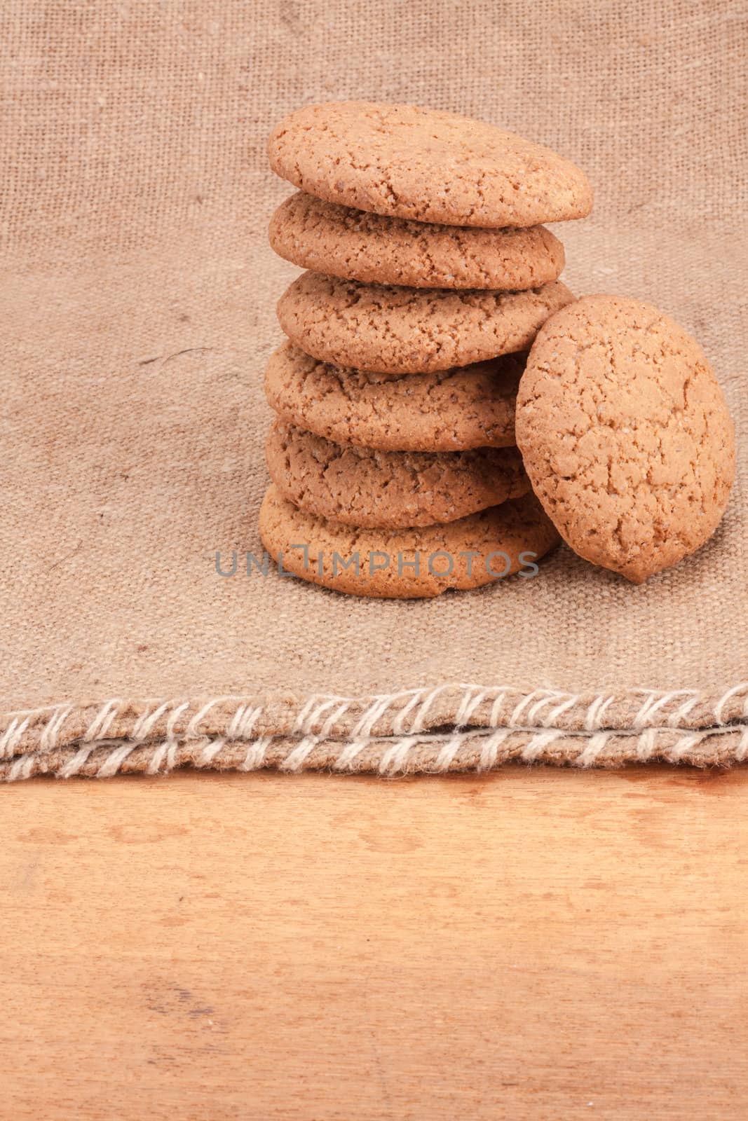Stacked Brown Cookies On Rustic Background by ryhor