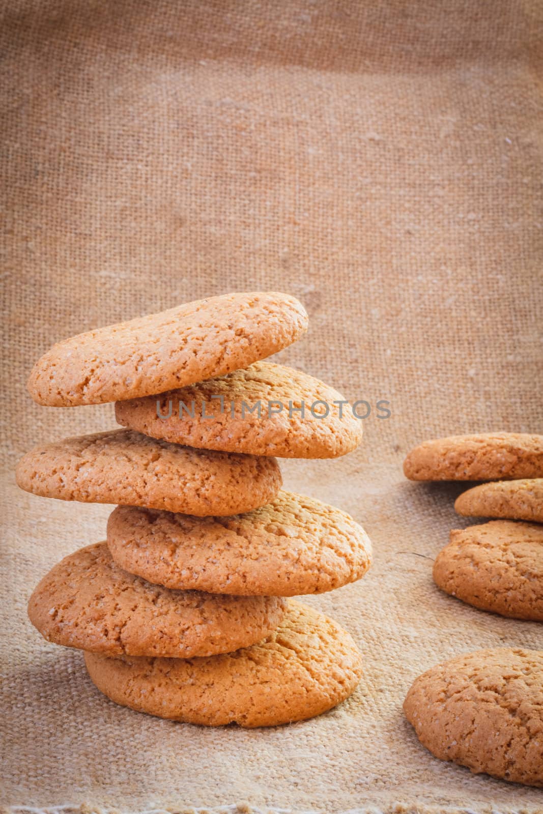 Stacked Brown Cookies On Rustic Background by ryhor