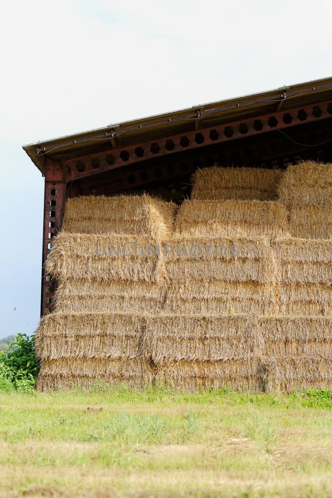 straw bales under the roof in the meadow