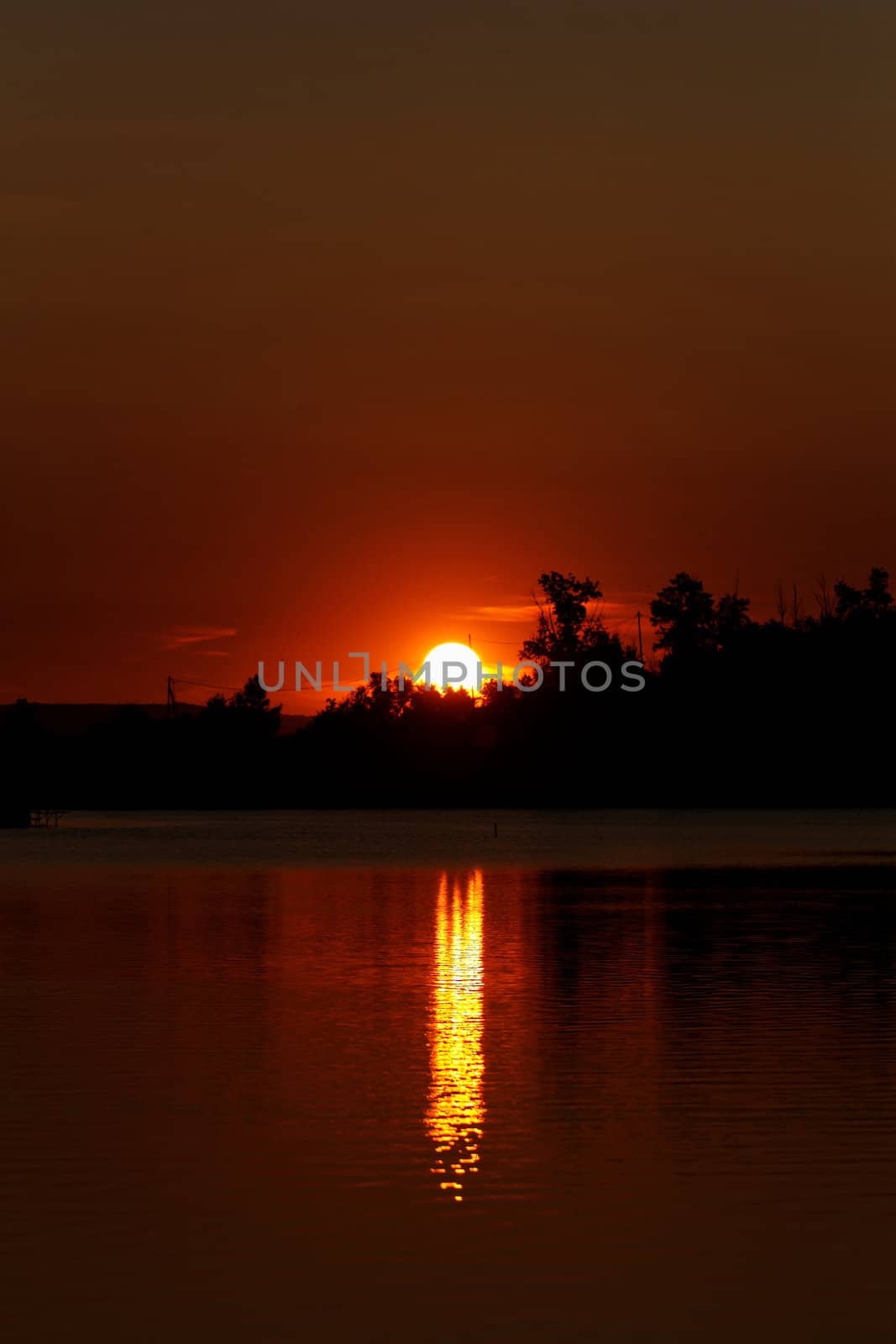 Colorful sunset over tranquil water surface.