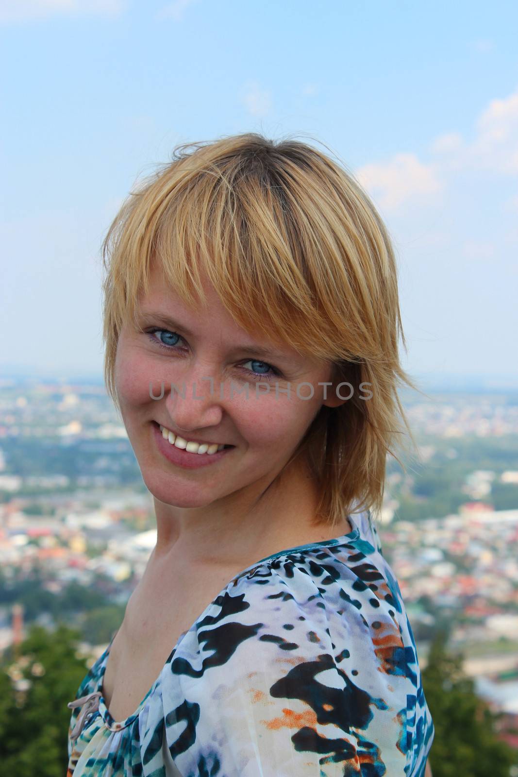 blue-eyed sympathetic girl on the background of view of city