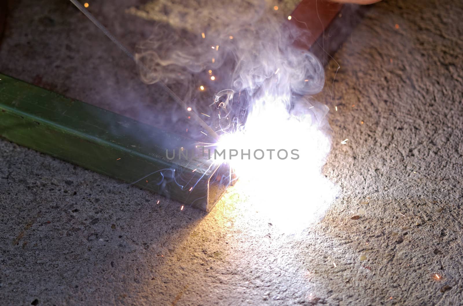 Iron welding with bright light and smoke at manufacturing