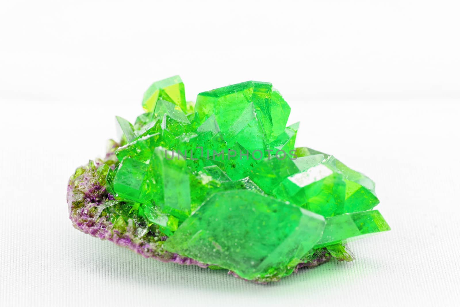 Close up picture about a crystal with emerald color on white background (green crystal)