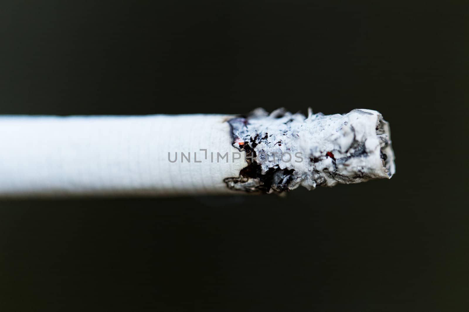 Smoking a cigarette against a dark background