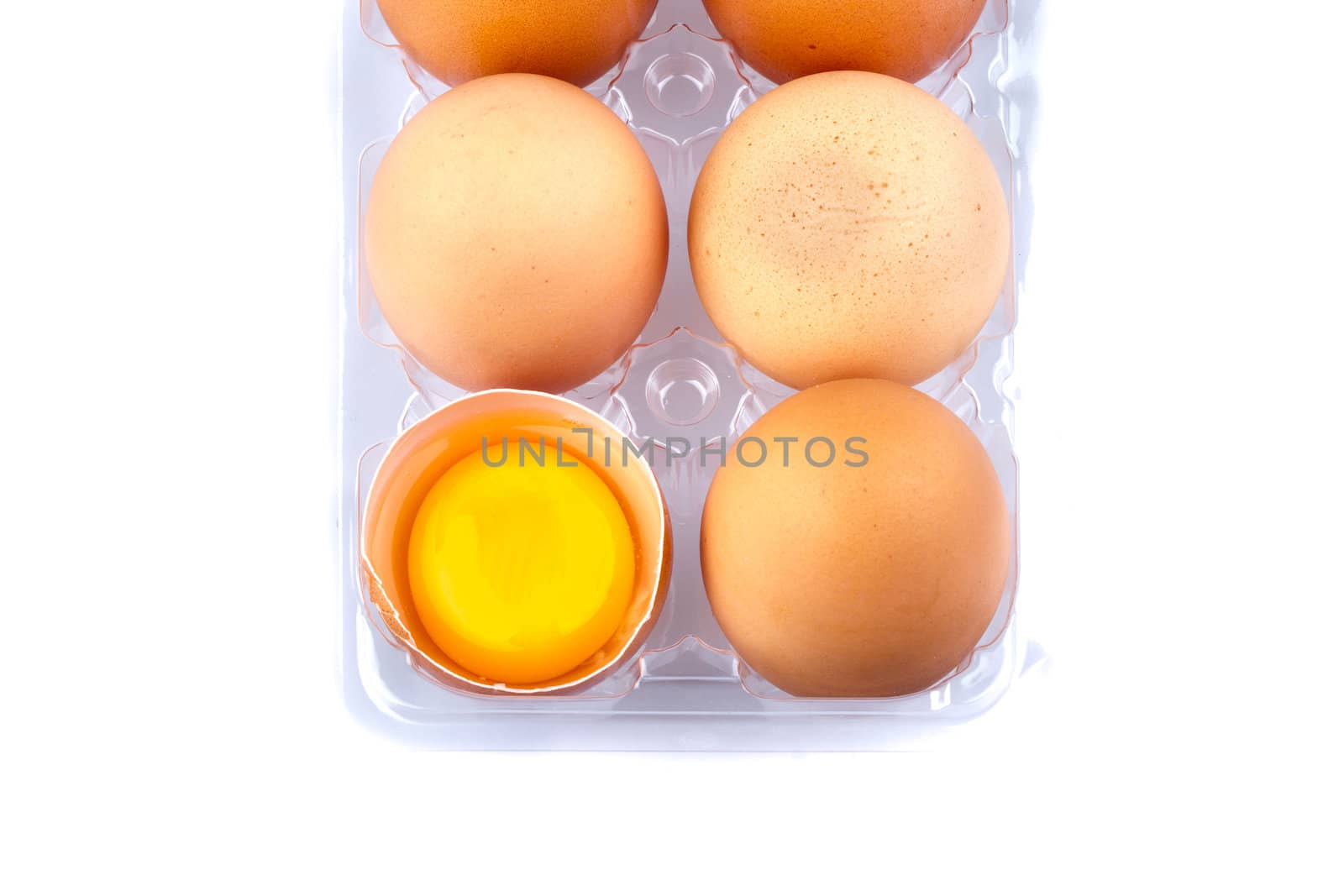 Eggs and yolk in a plastic transparent package on white background