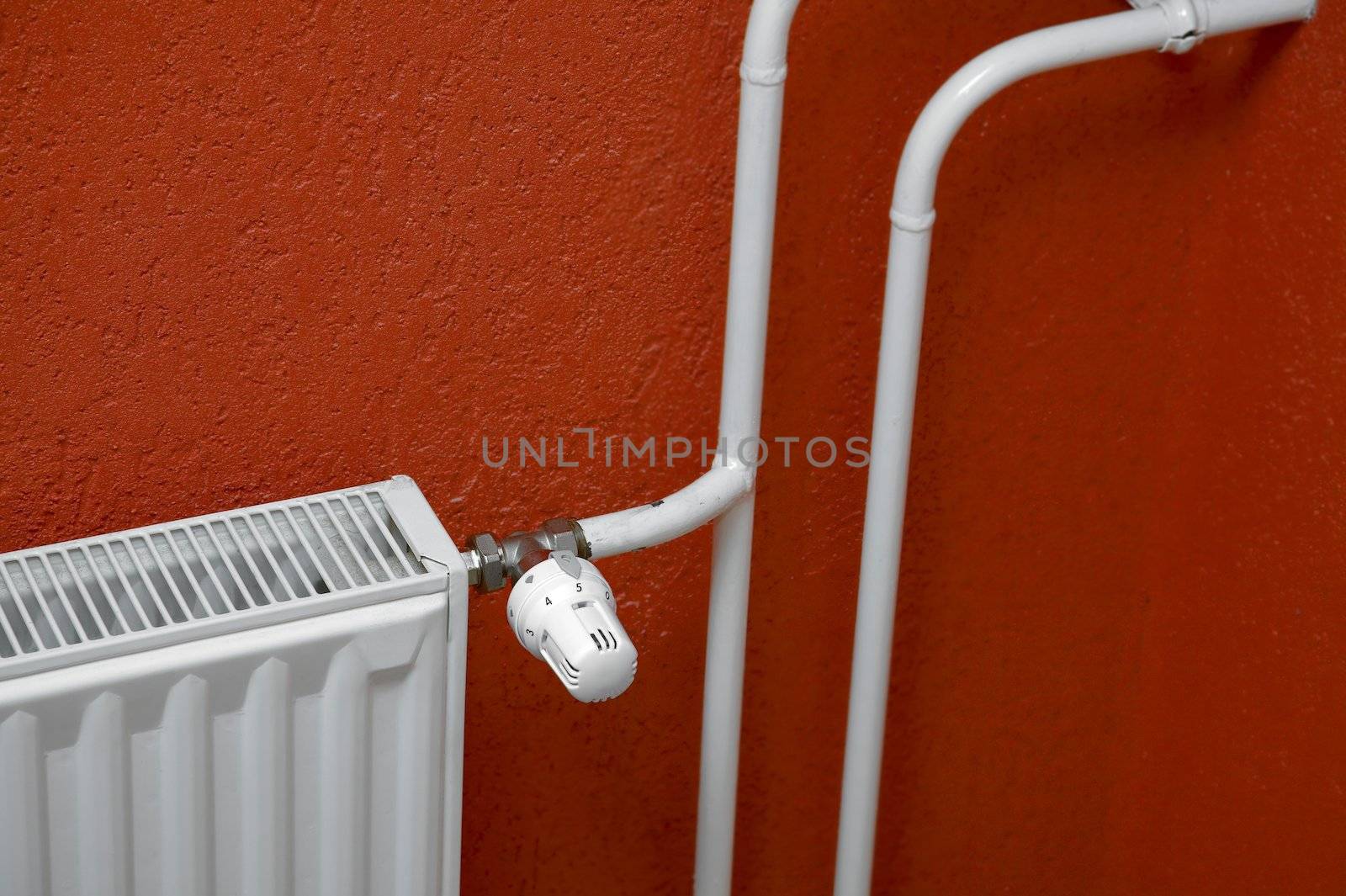 Heating radiator detail against orange wall