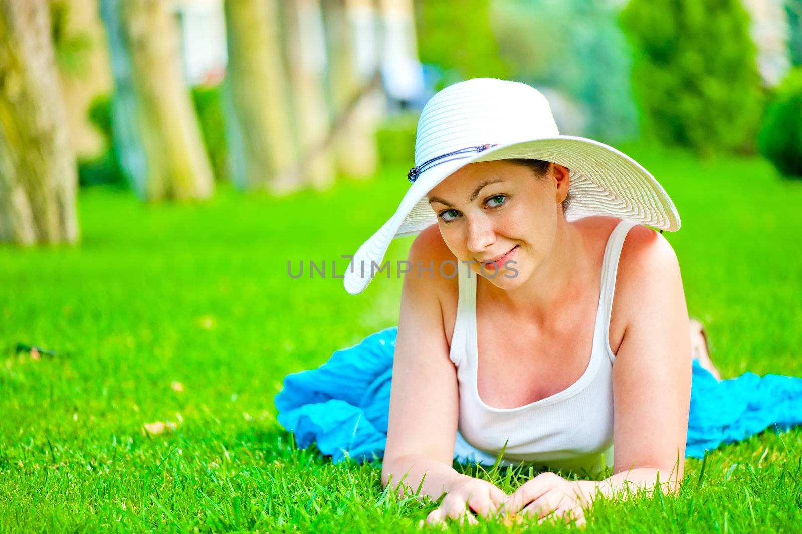 girl lies on the grass and looking at the camera