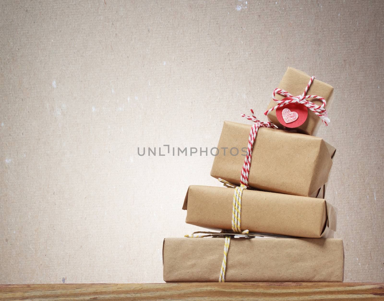 Stack of handcraft gift boxes on wooden board with a natural textured background