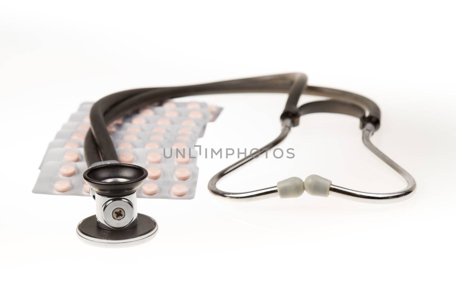 Stethoscope and tablets on isolated white background