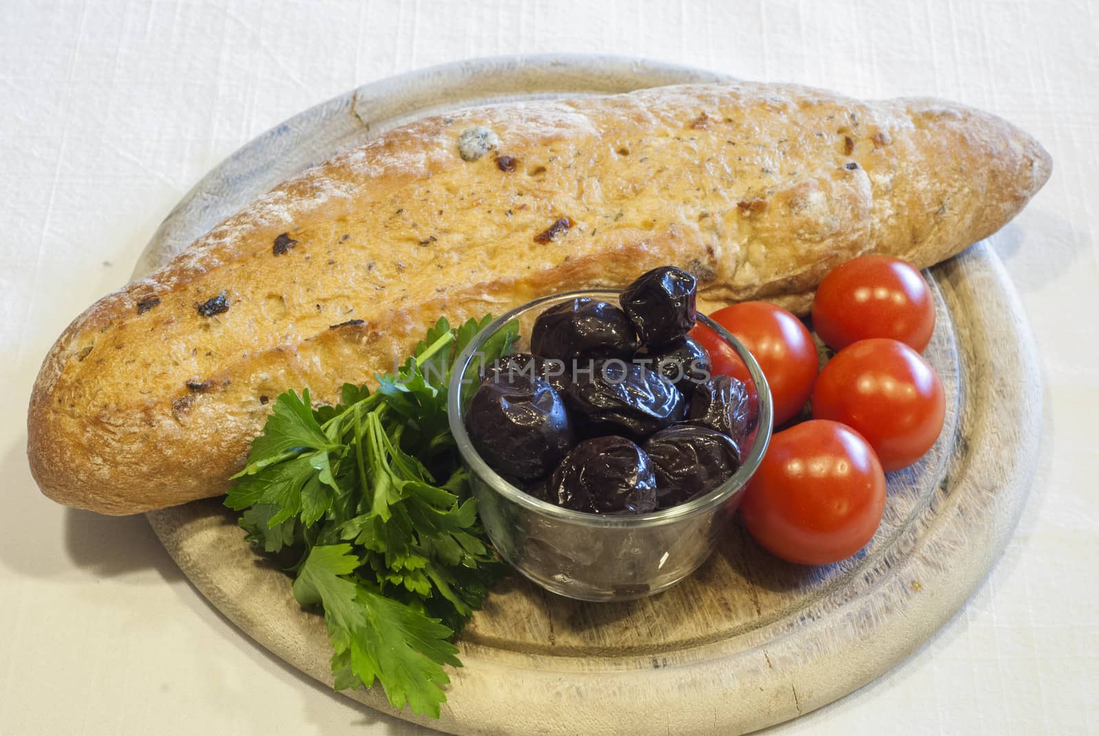 Homemade organic baguette bread with olives, cherry tomatoes and parsley