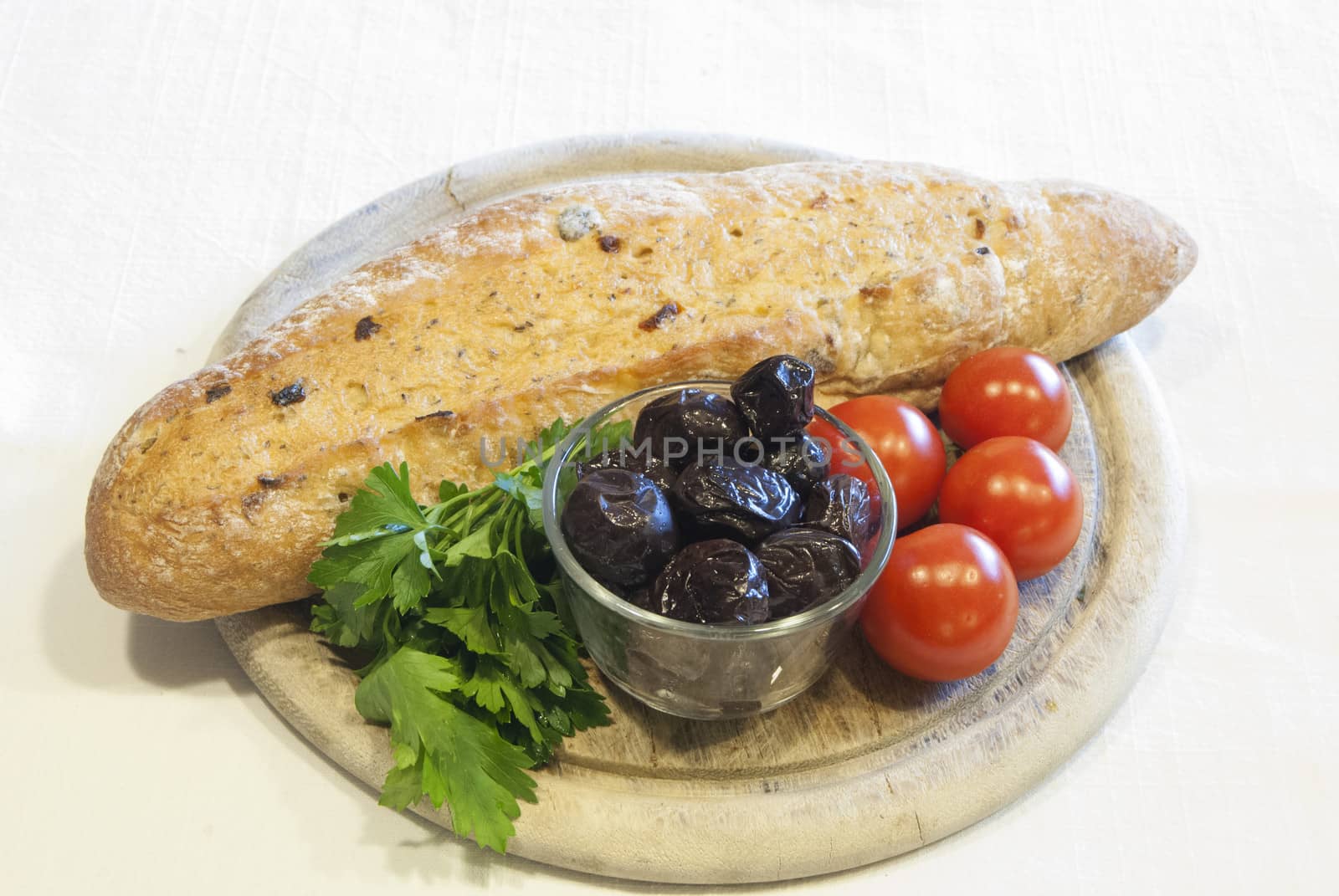 Homemade organic baguette bread with olives, cherry tomatoes and parsley