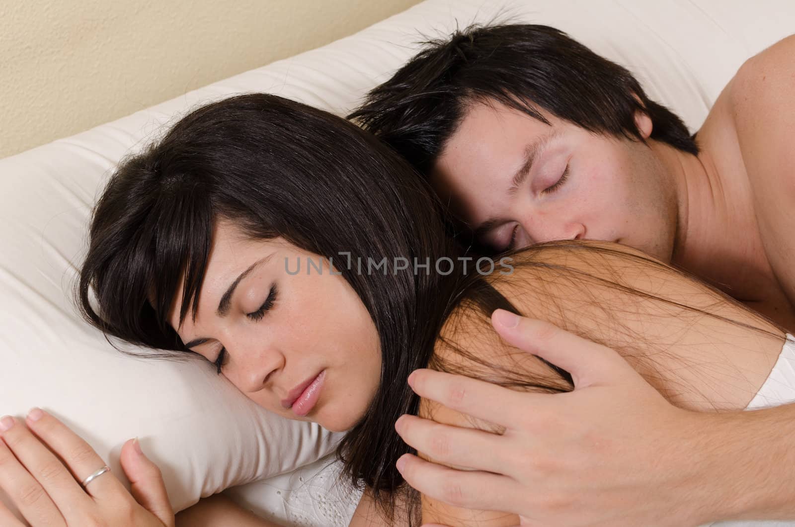 Couple in their 20s relaxed and sleeping in an embrace