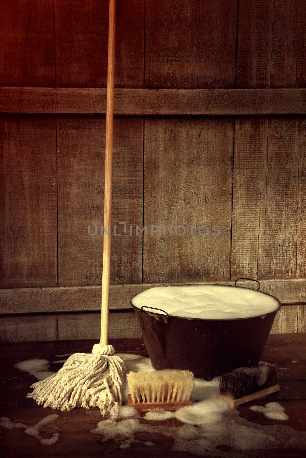 Cleaning mop and bucket with wet soapy floor by Sandralise
