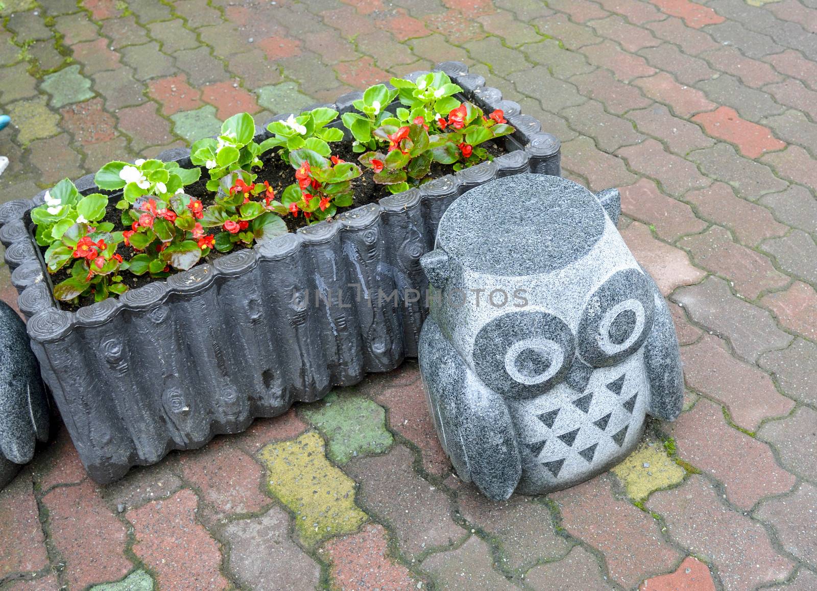 Rock owl statue with flower by gjeerawut