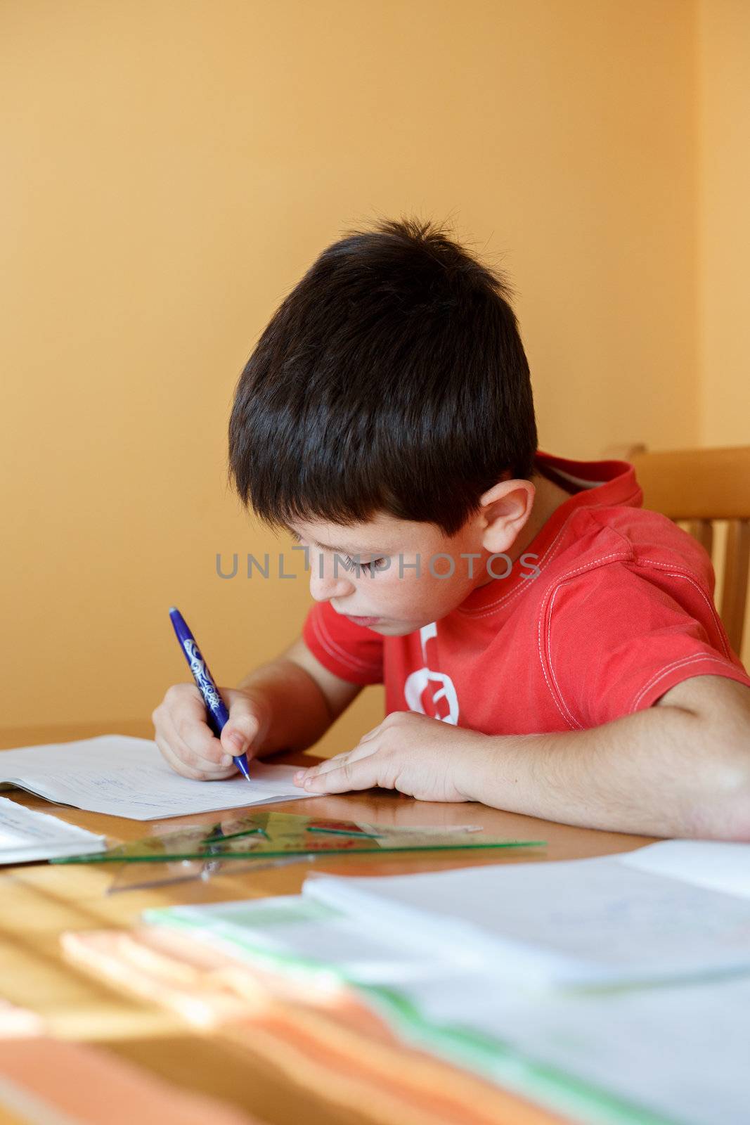 boy doing school homework from mathematics in workbook