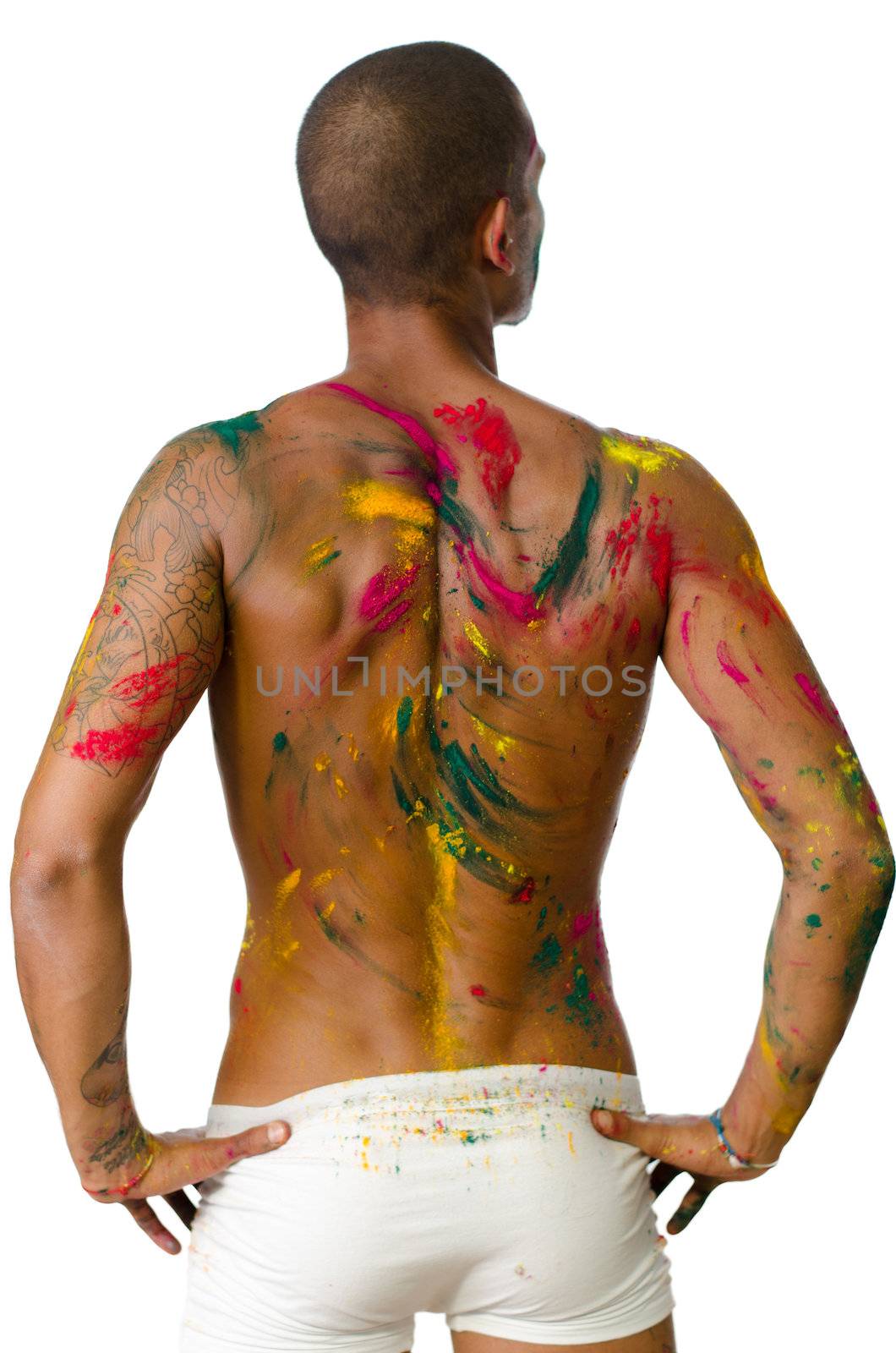 Back of shirtless young man, skin painted all over with bright colors  by artofphoto