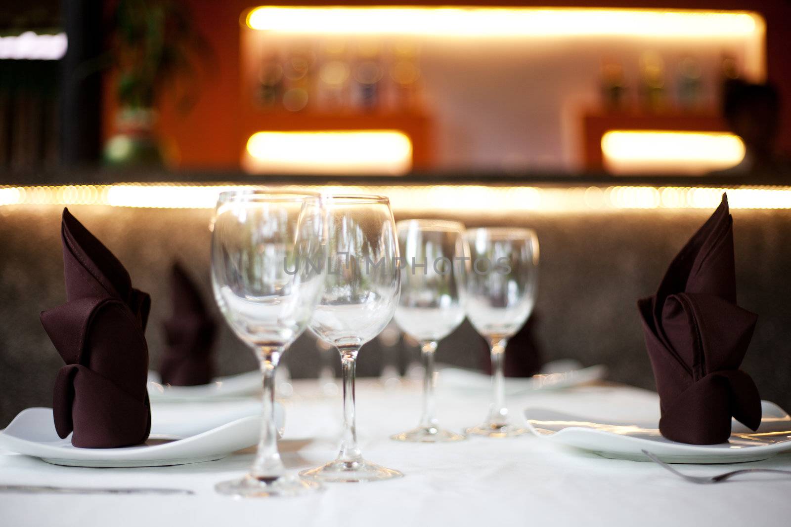 Restaurant table with two menu sets and a bar in the background