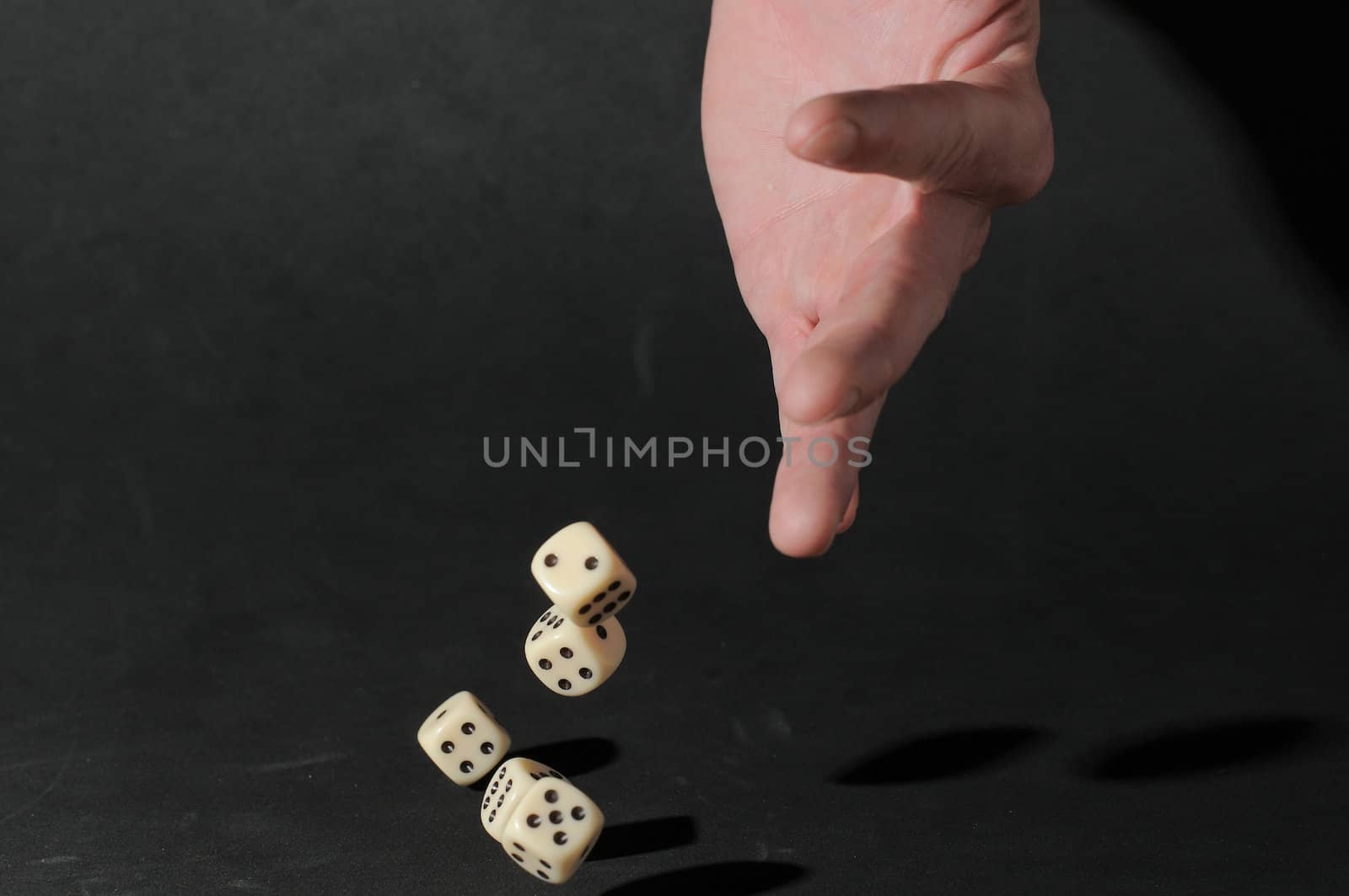 One Left Male Hand Playing Dice on a Black Background