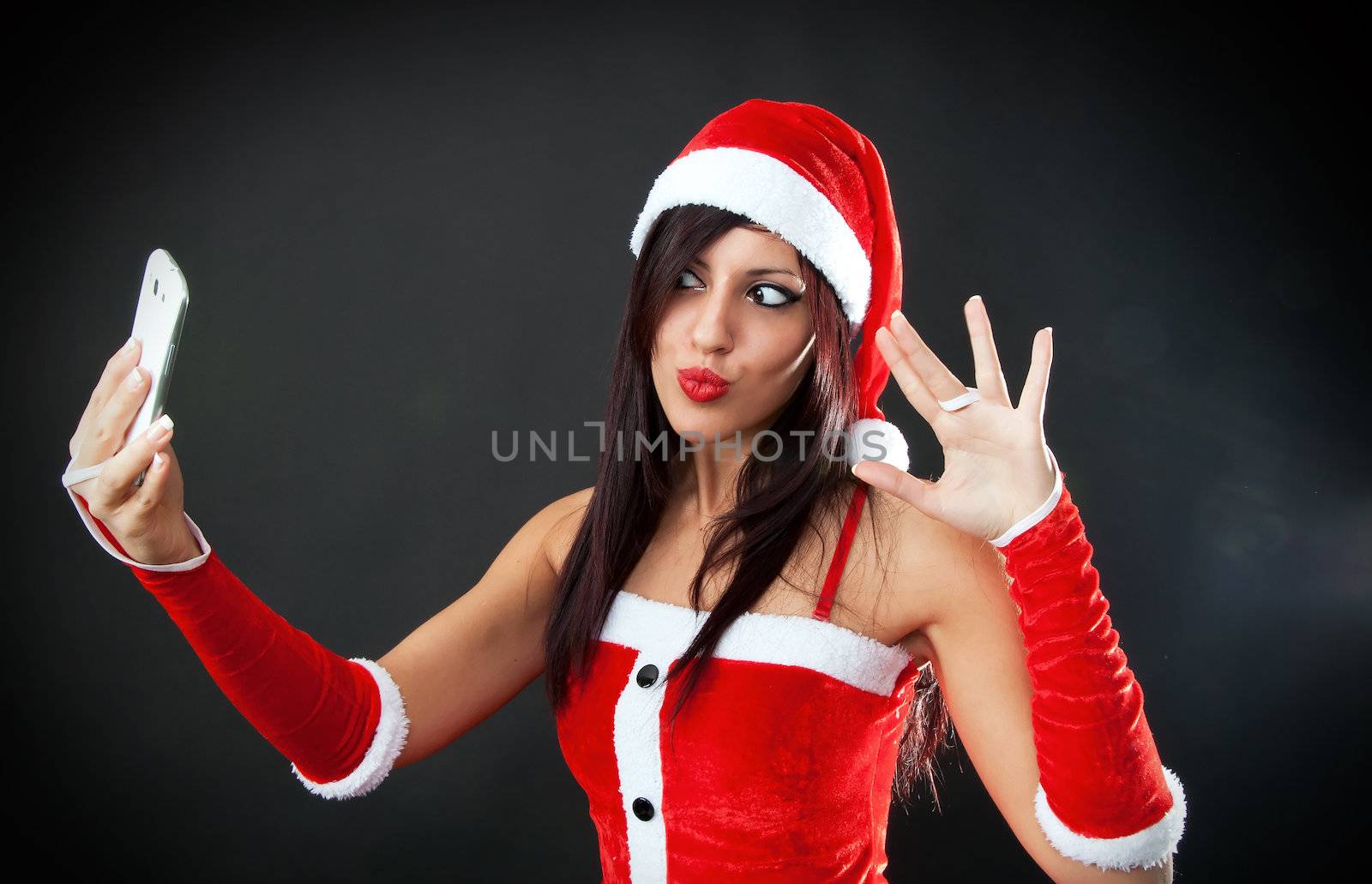 Portrait of beautiful sexy girl wearing santa claus clothes with smartphone