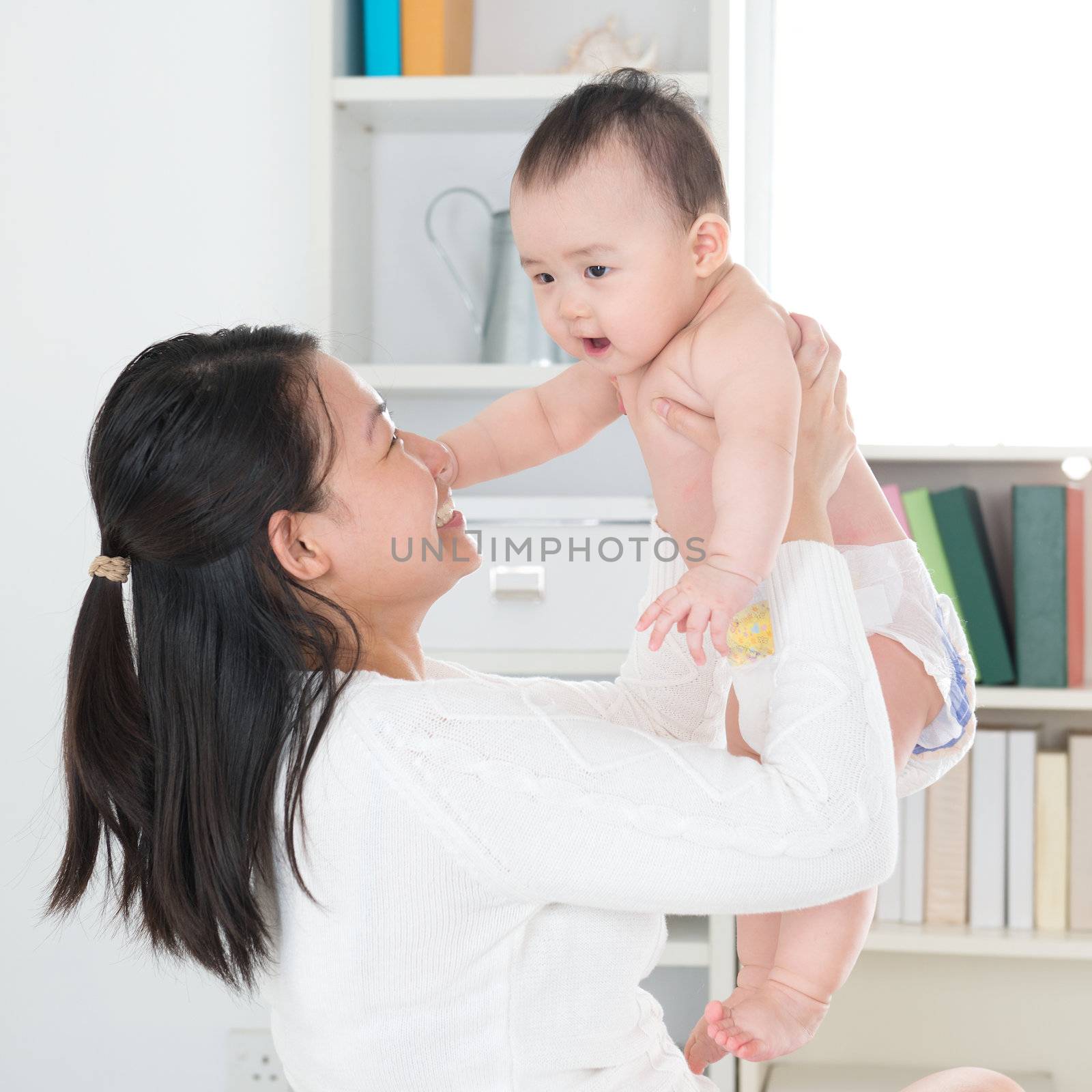 Asian mother and six months old baby girl at home.