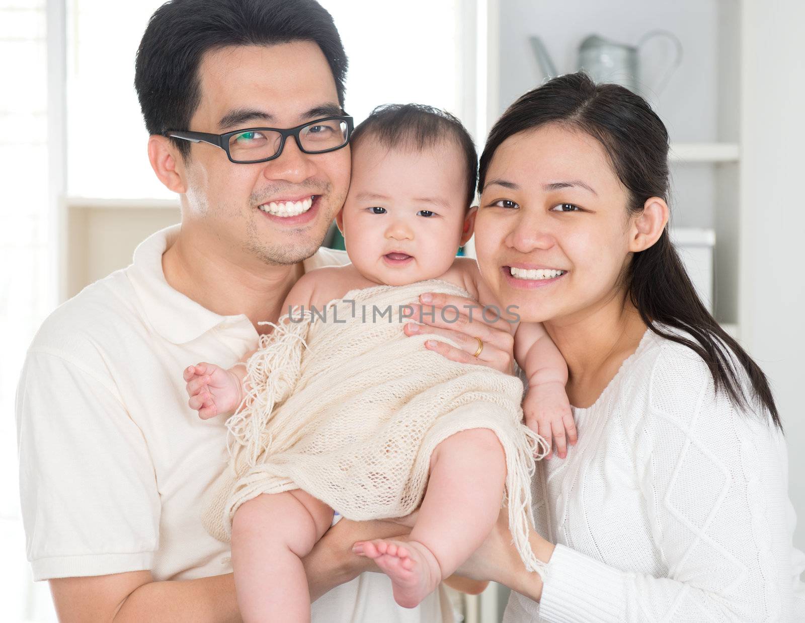 Portrait of Asian parents and six months old baby girl at home. Asian family.
