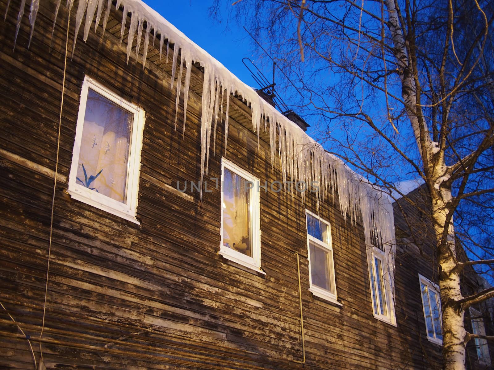 Icicles on the roof of a wooden house