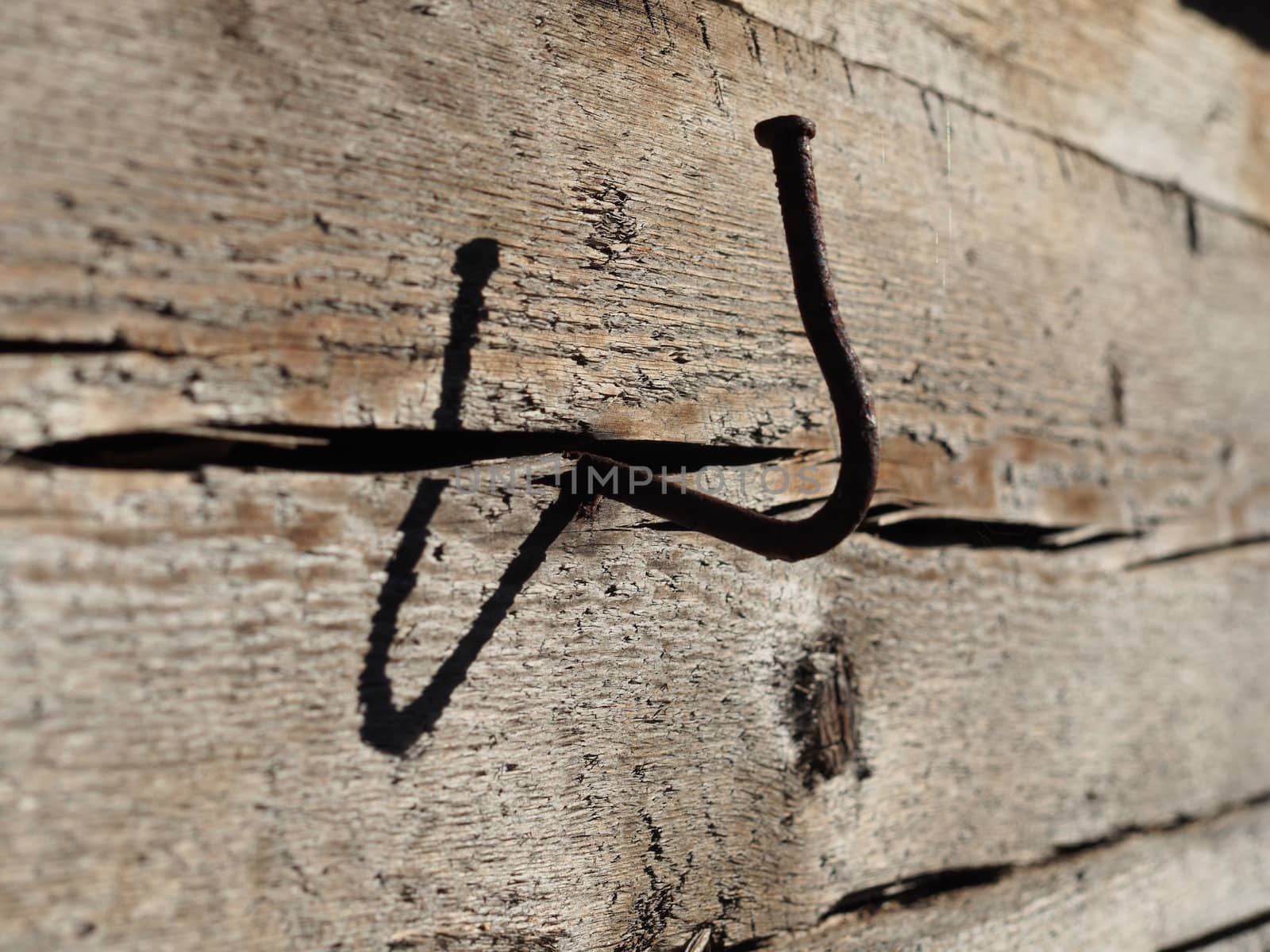 bent nail into a wooden wall