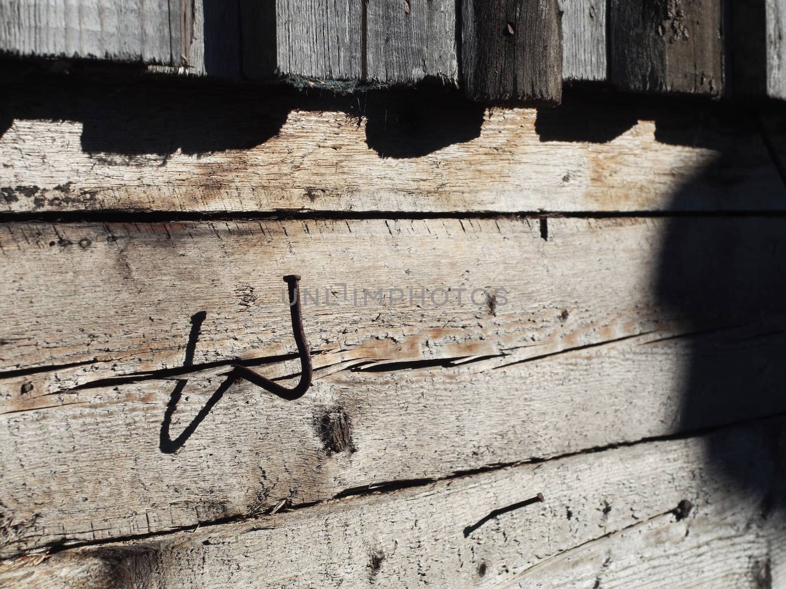 bent nail into a wooden wall