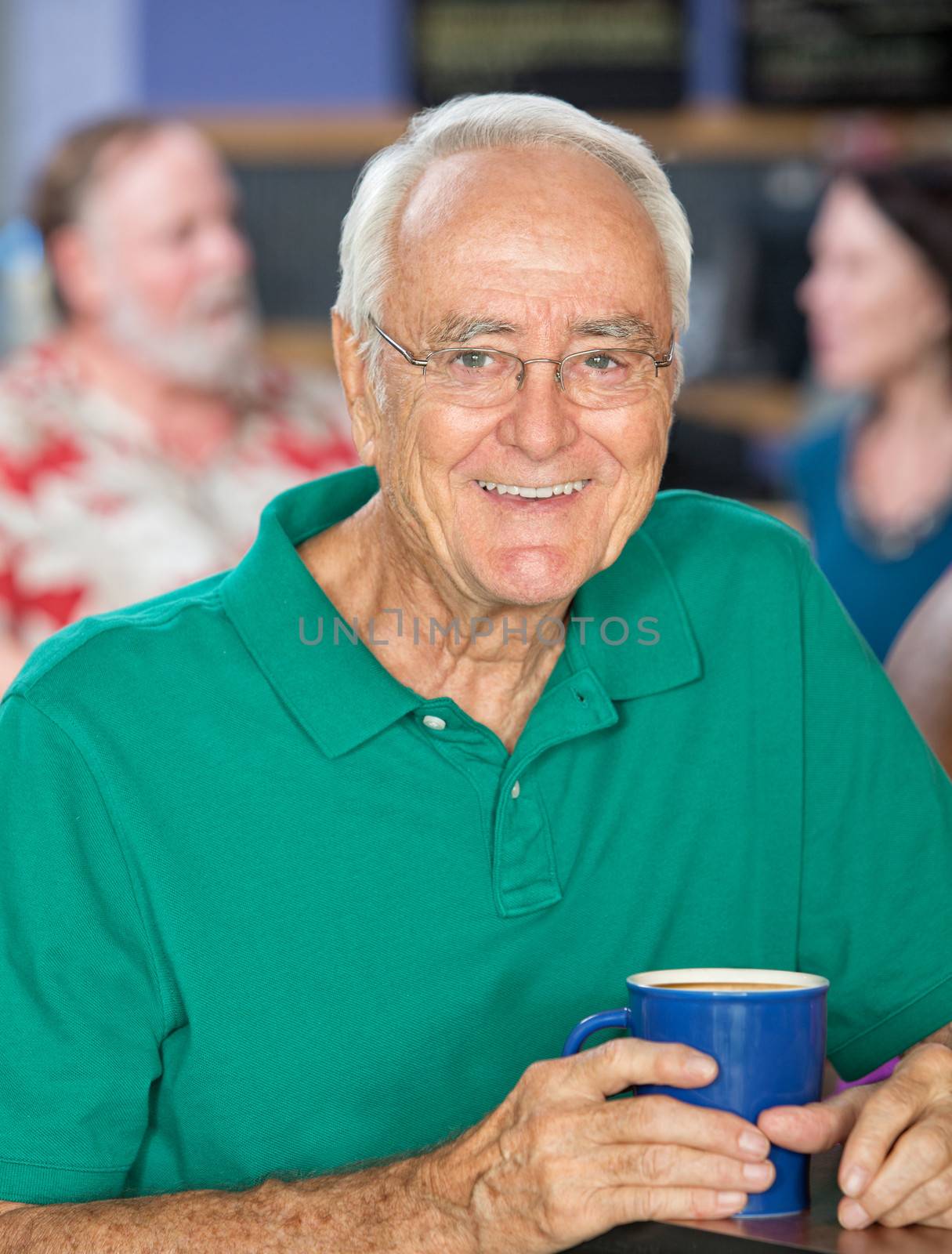Handsome senior male smiling with coffee mug