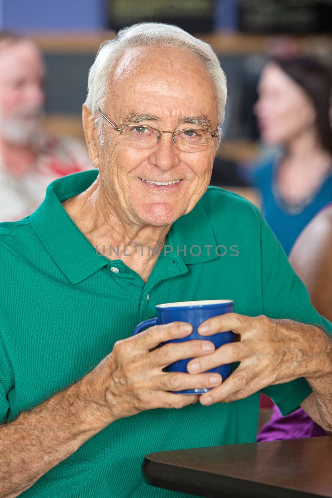 Happy single mature male holding coffee mug