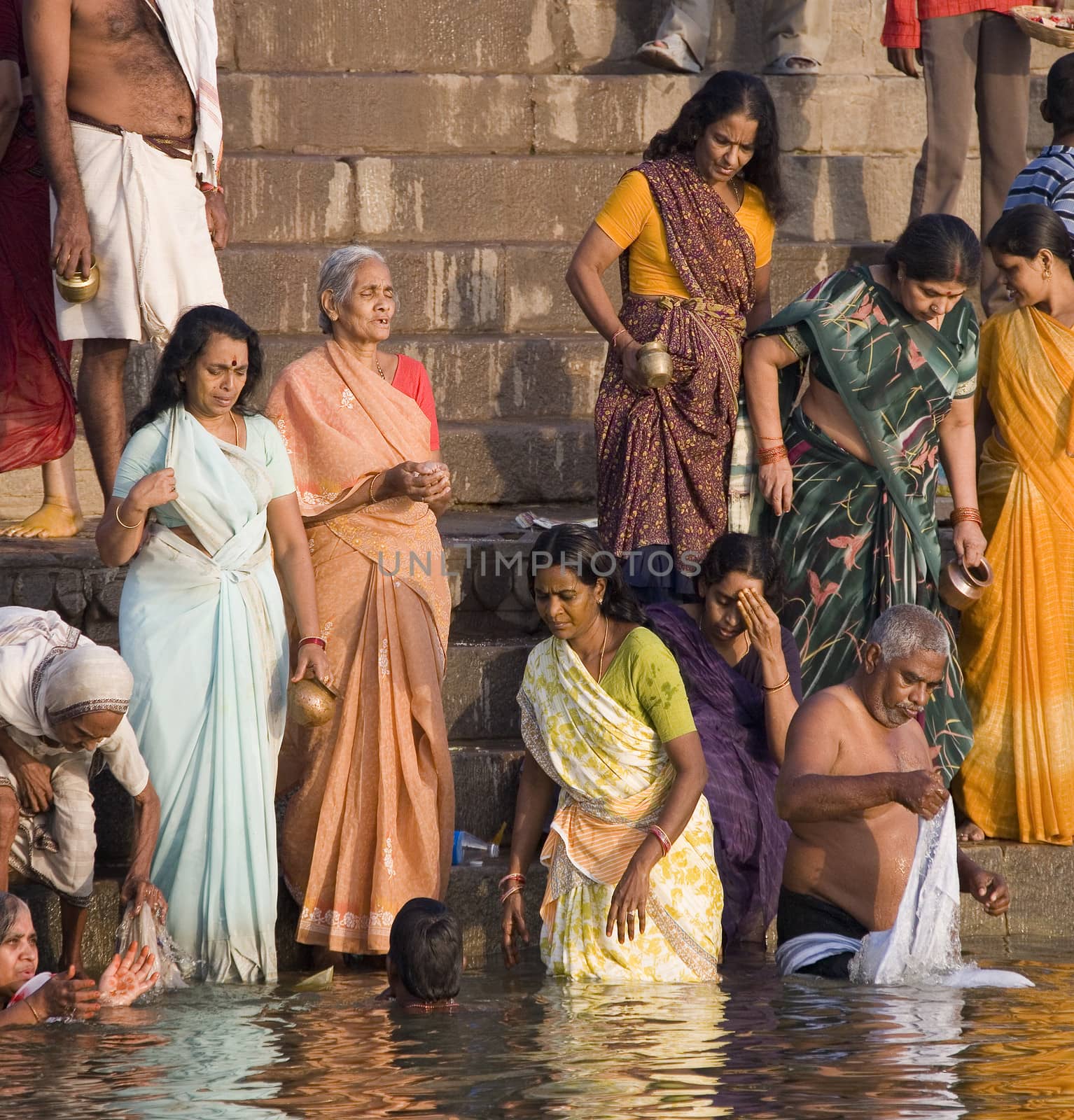 Group of pilgrims on the Hindu ghats on the banks of the Holy River Ganges (Ganga) in Varanasi (Benares) in the Uttar Pradesh region of northern India.