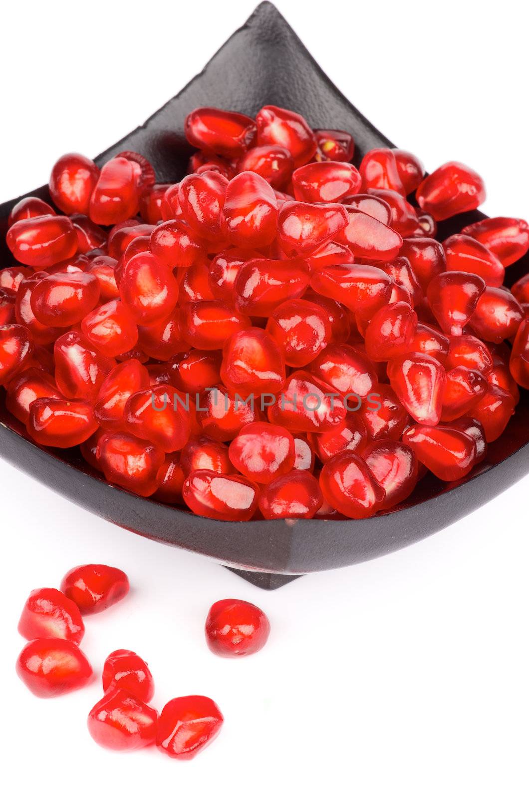 Perfect Ripe Pomegranate Seeds in Black Square Plate isolated on white background