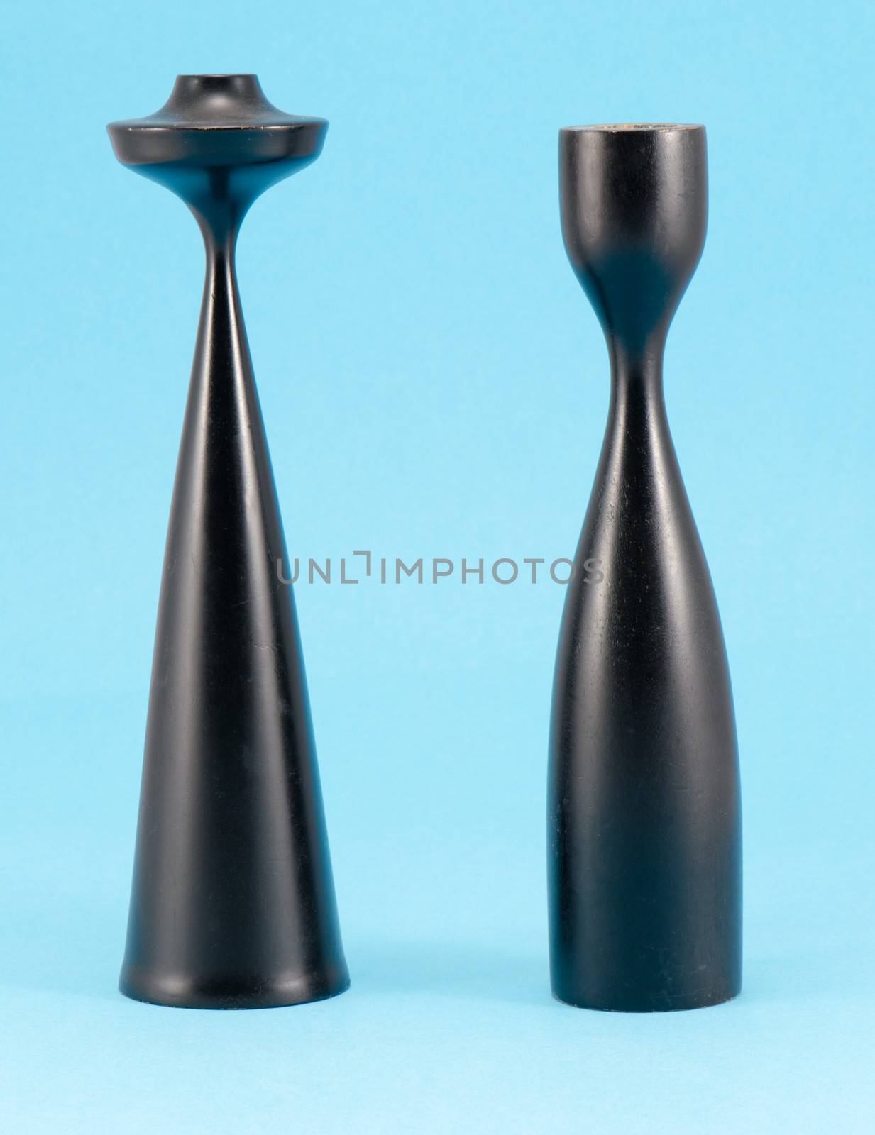 retro high curvy wooden candlesticks candle sticks painted black on blue background.
