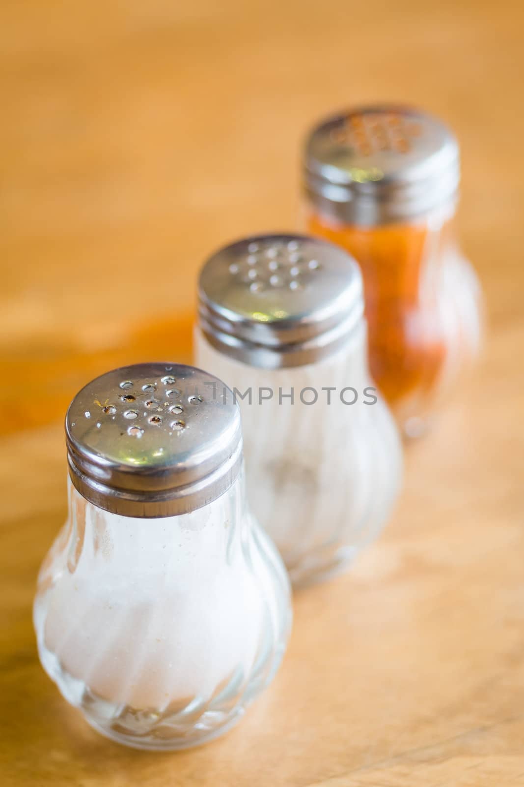 salt and pepper in shaker glass bottle on wood table by moggara12