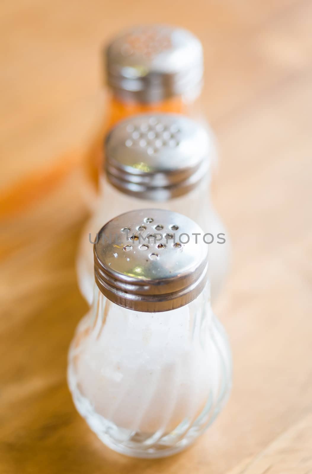 salt and pepper in shaker glass bottle on wood table by moggara12