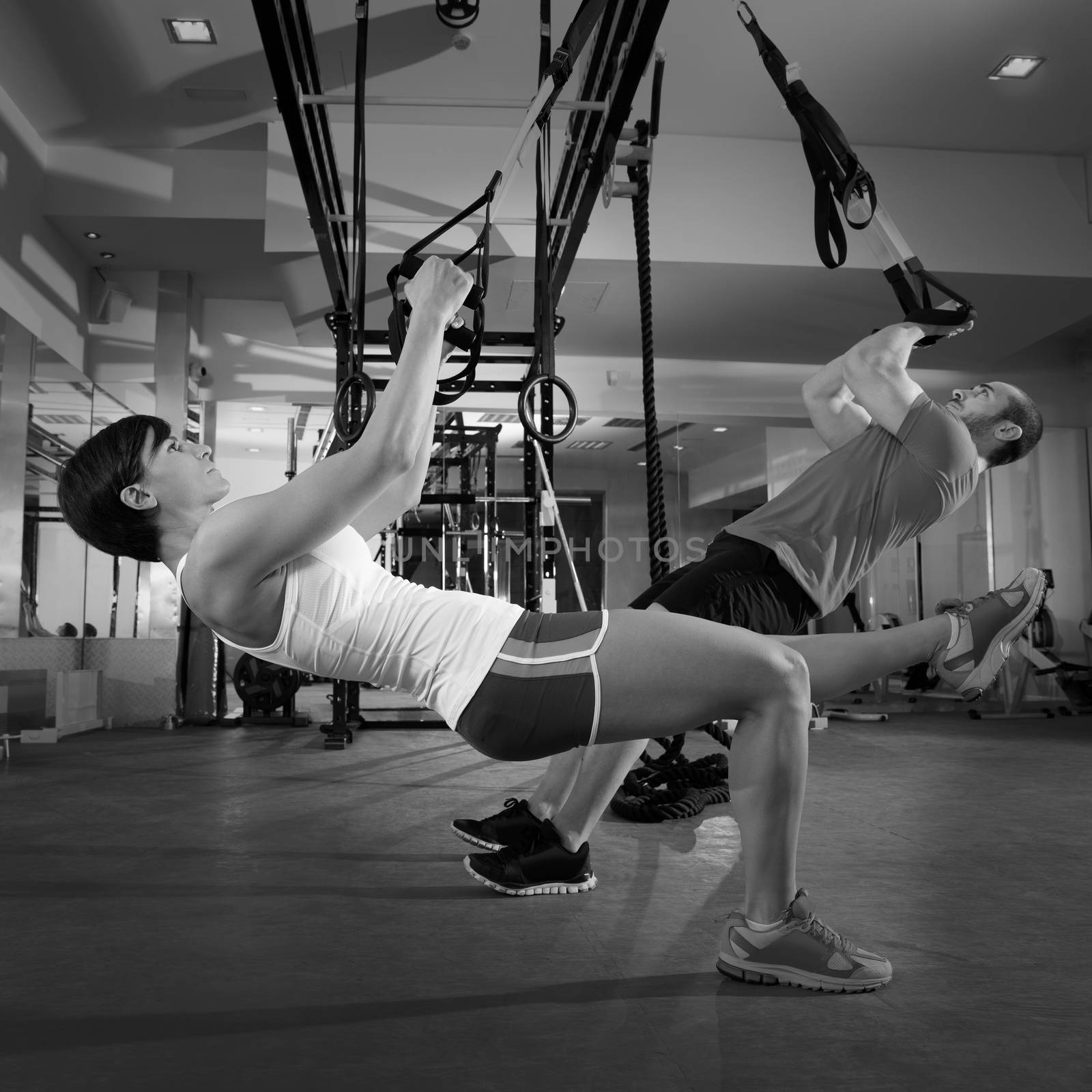 Fitness TRX training exercises at gym woman and man push-up workout