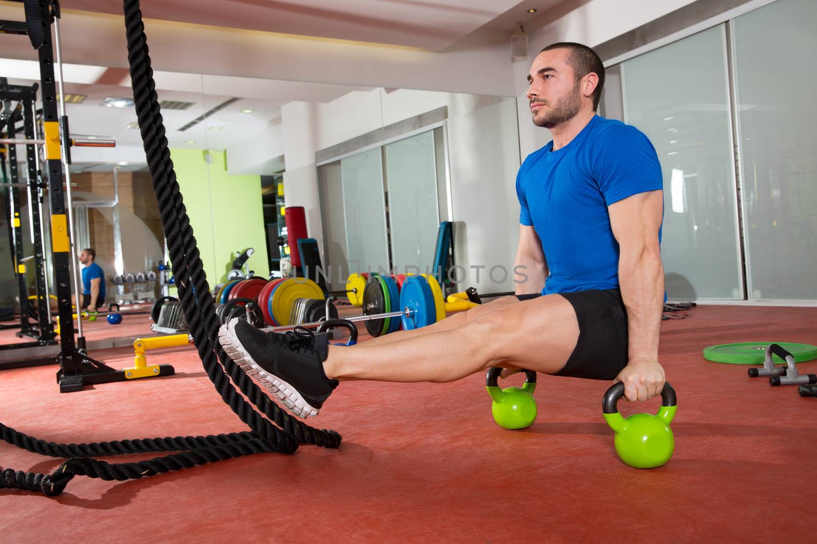 Crossfit fitness man L-sits Kettlebells L sits exercise at gym workout
