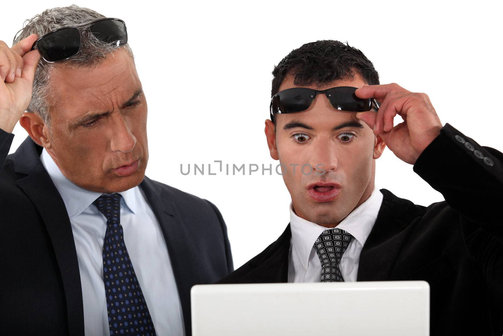 Businessmen looking at their laptops by phovoir