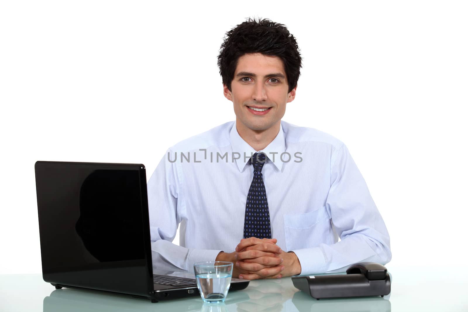Man sat at desk with glass of water by phovoir